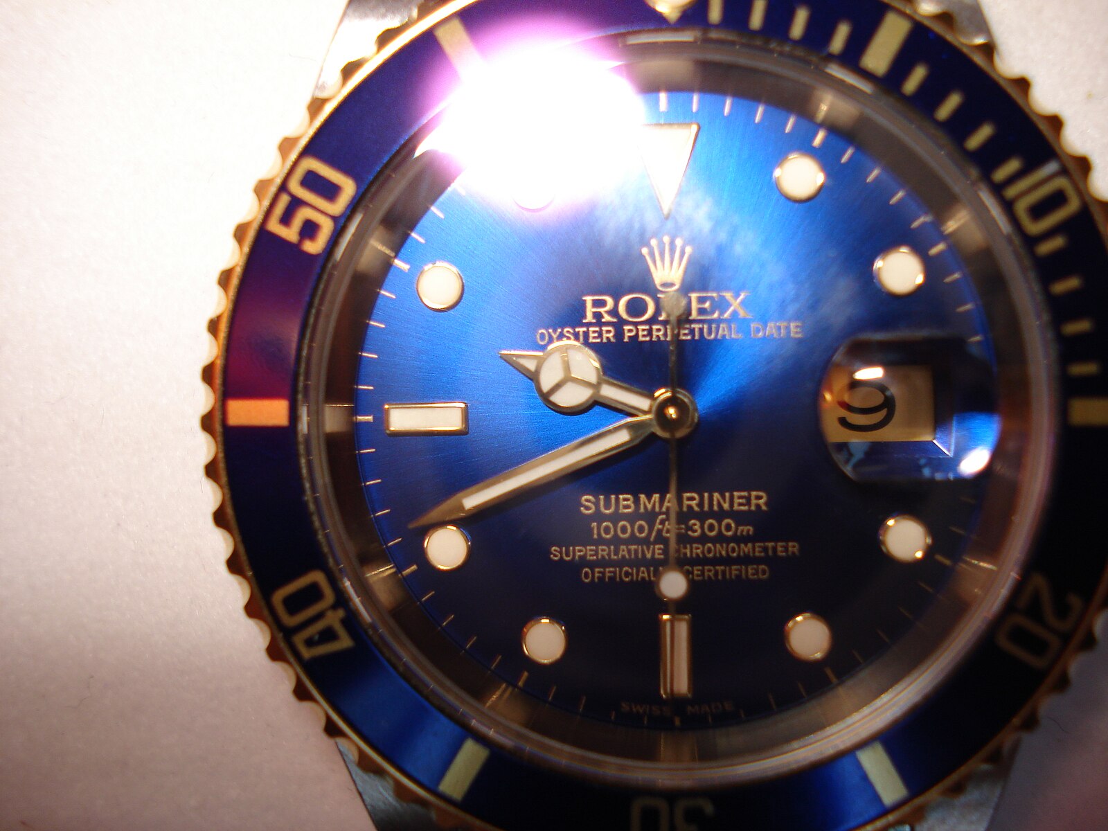 Tiny laser-etched Rolex crown logo on the crystal at 6 o'clock